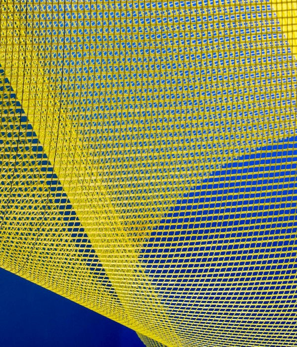 Dynamic abstract image featuring yellow mesh patterns against a deep blue background, creating an artistic visual.